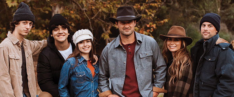 Group of people wearing and showcasing their hats and fall attire smiling