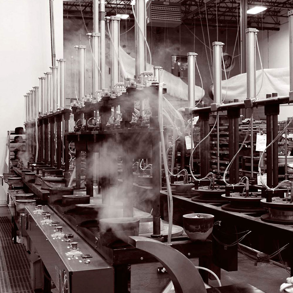 Heavy machinery made for creating hats with steam rising from a vent in the center